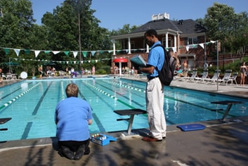 staff testing the pool chemicals next to diving platform