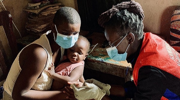 Community healthcare worker giving child a malaria vaccine.