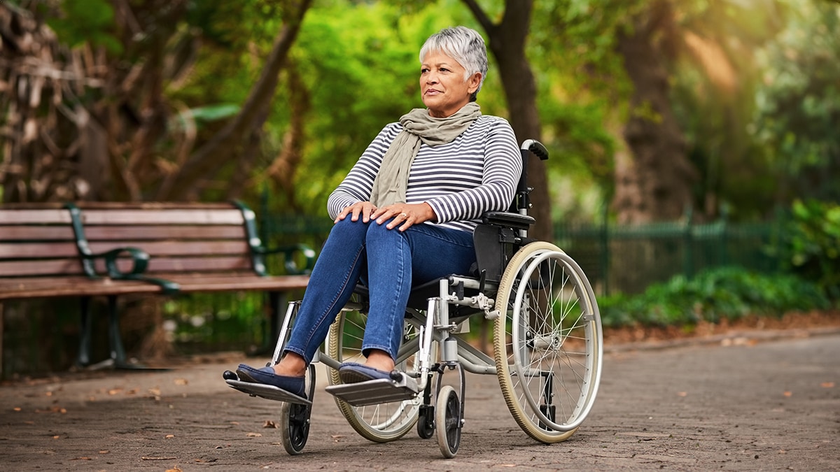 Mature woman sitting in a wheelchair at the park