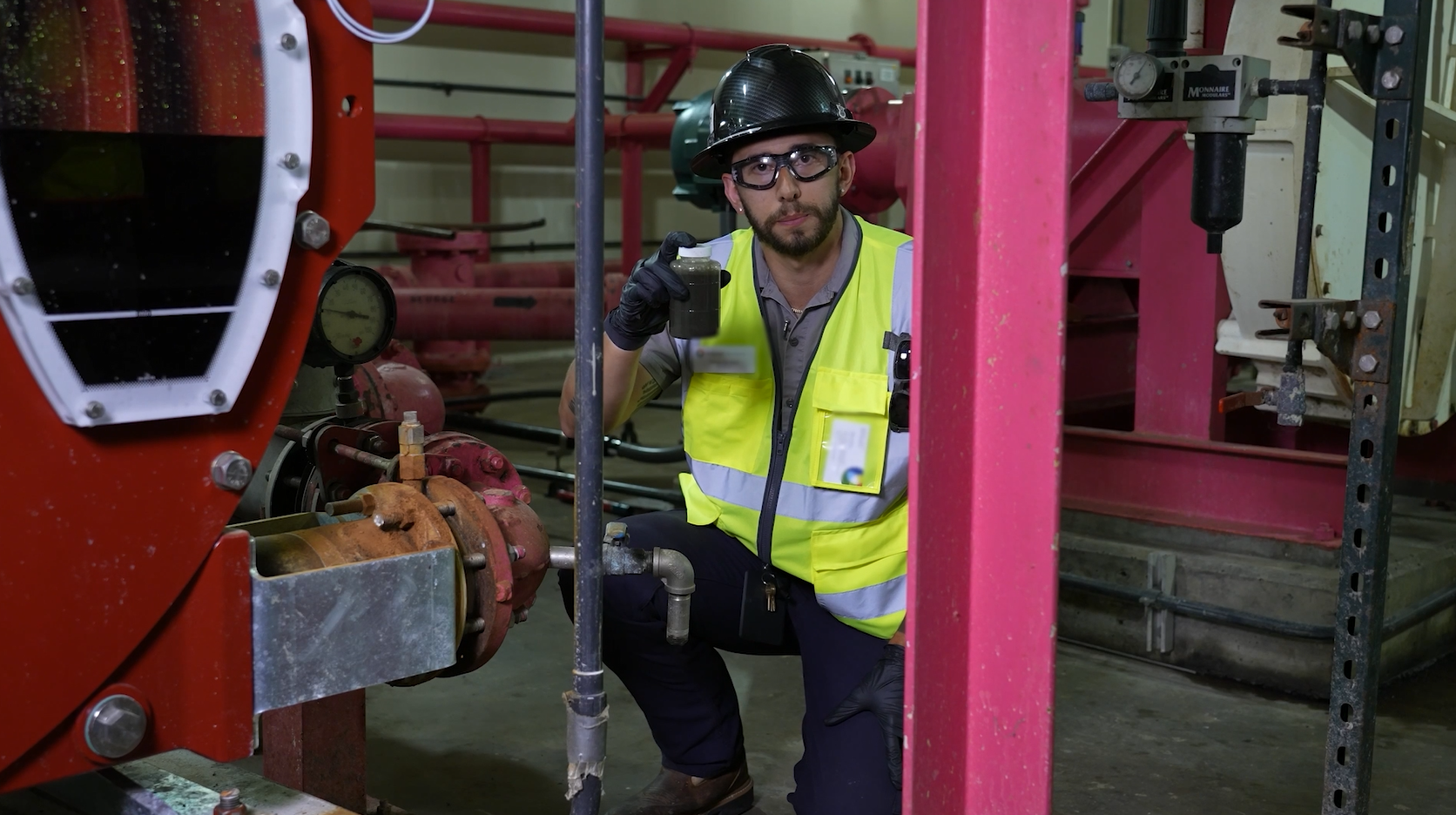 A worker at the F. Wayne Hill Wastewater Treatment Plant holding a sample of wastewater.