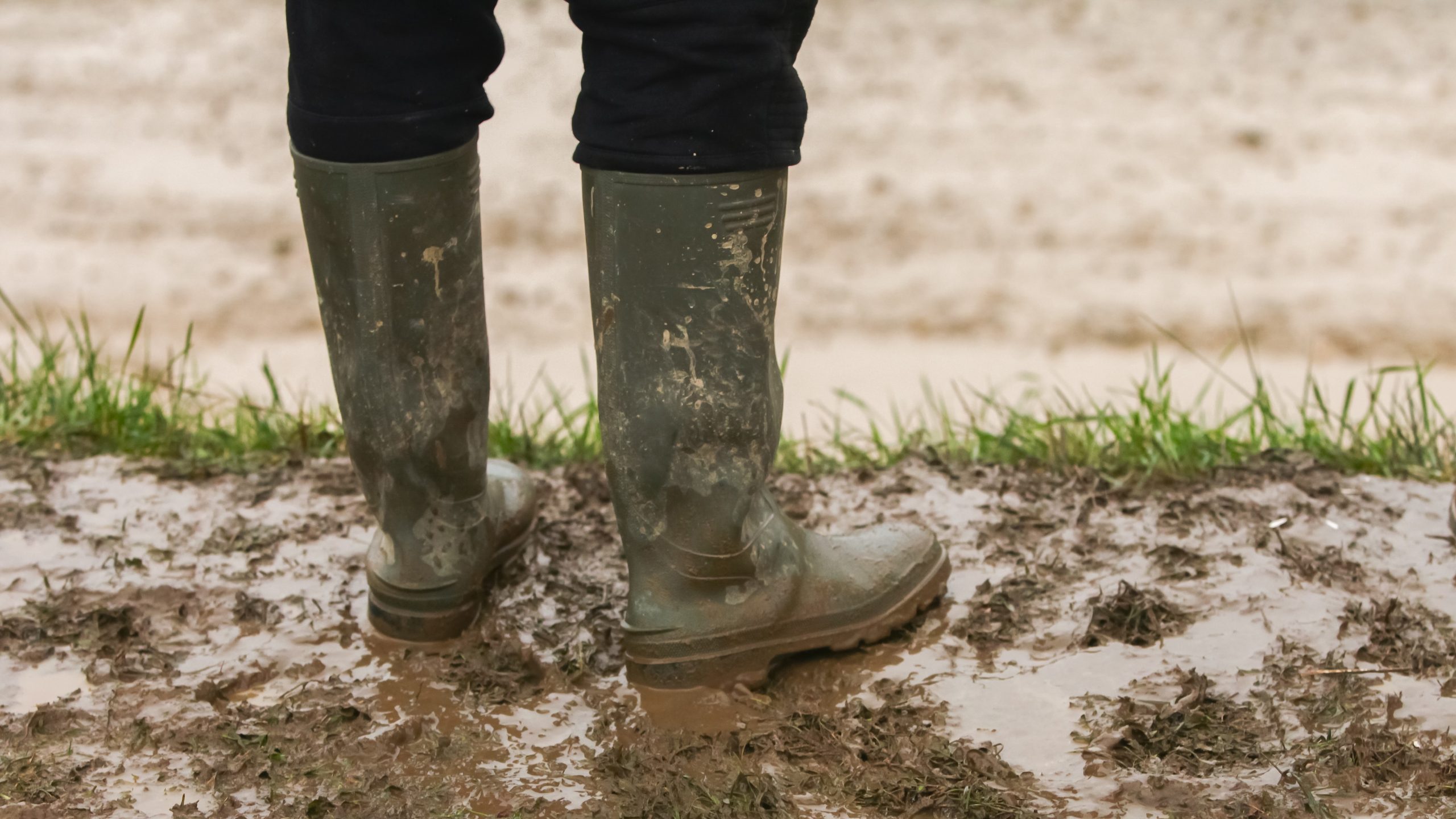 A person wears boots in the mud.