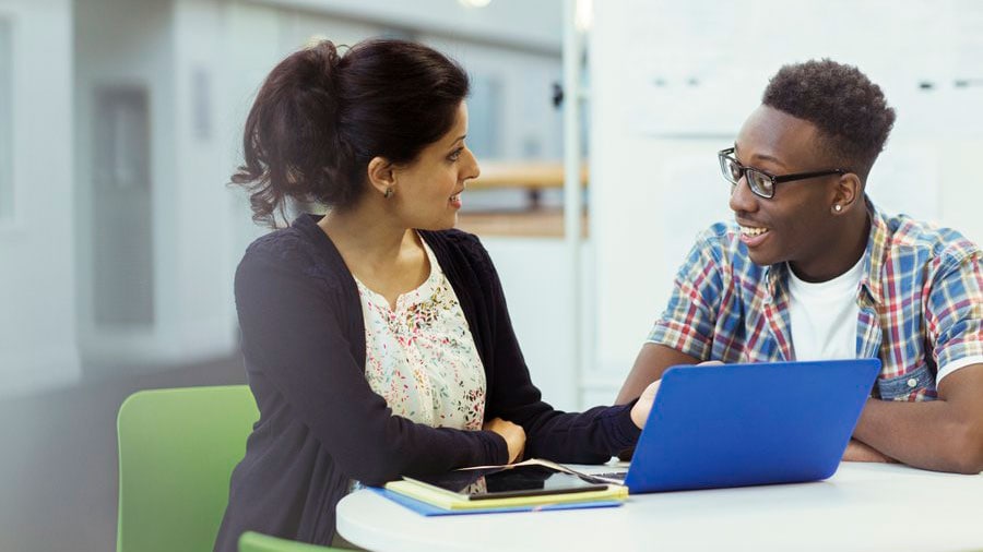 A counselor speaking with a teenage student.