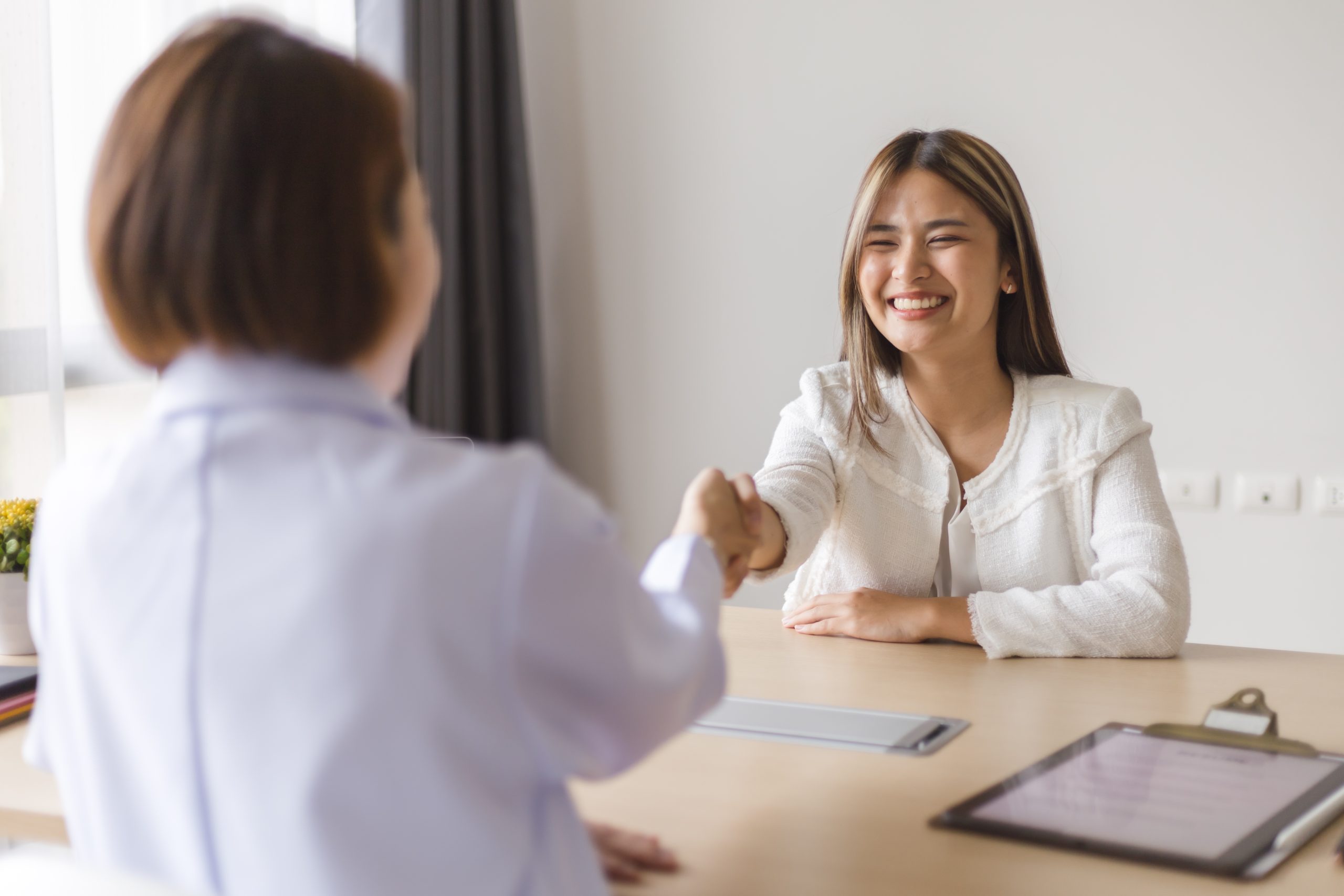 Two women shaking hands in an office