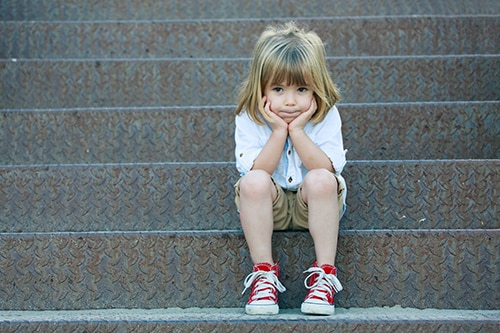 Sad child sitting on staircase