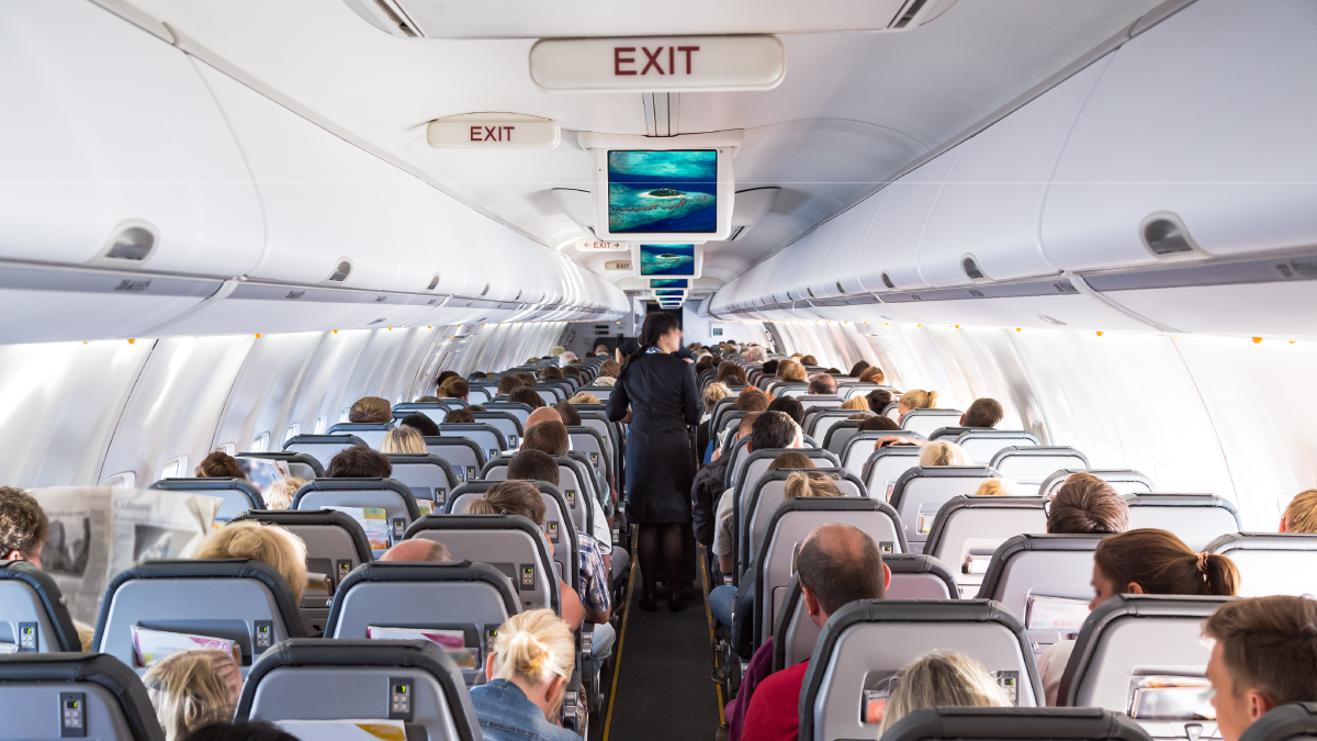 The image shows a child walking down the aisle of a loaded airplane.