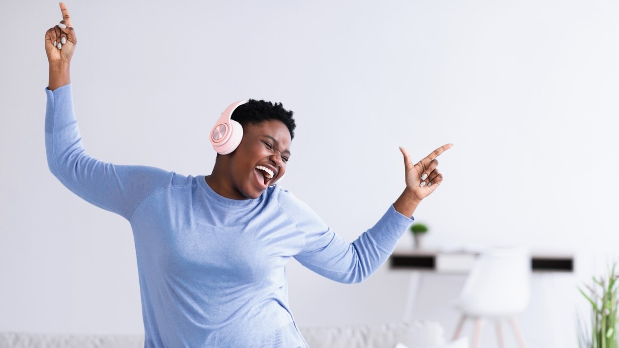 Woman wearing headphones and dancing.