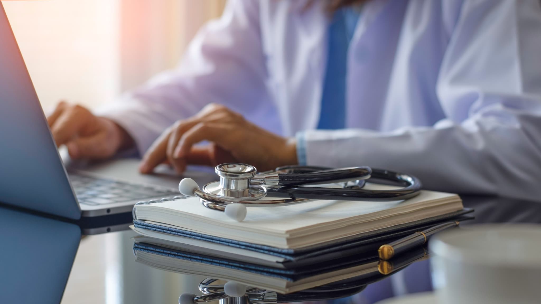 A male doctor at a desk on a laptop