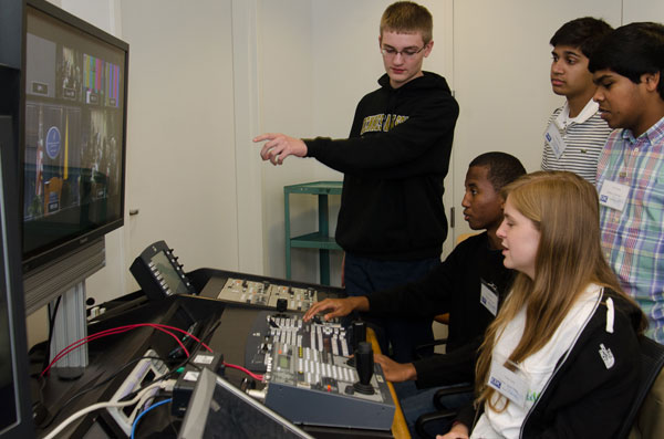 Students work behind the scenes to make sure the press conference runs smoothly.