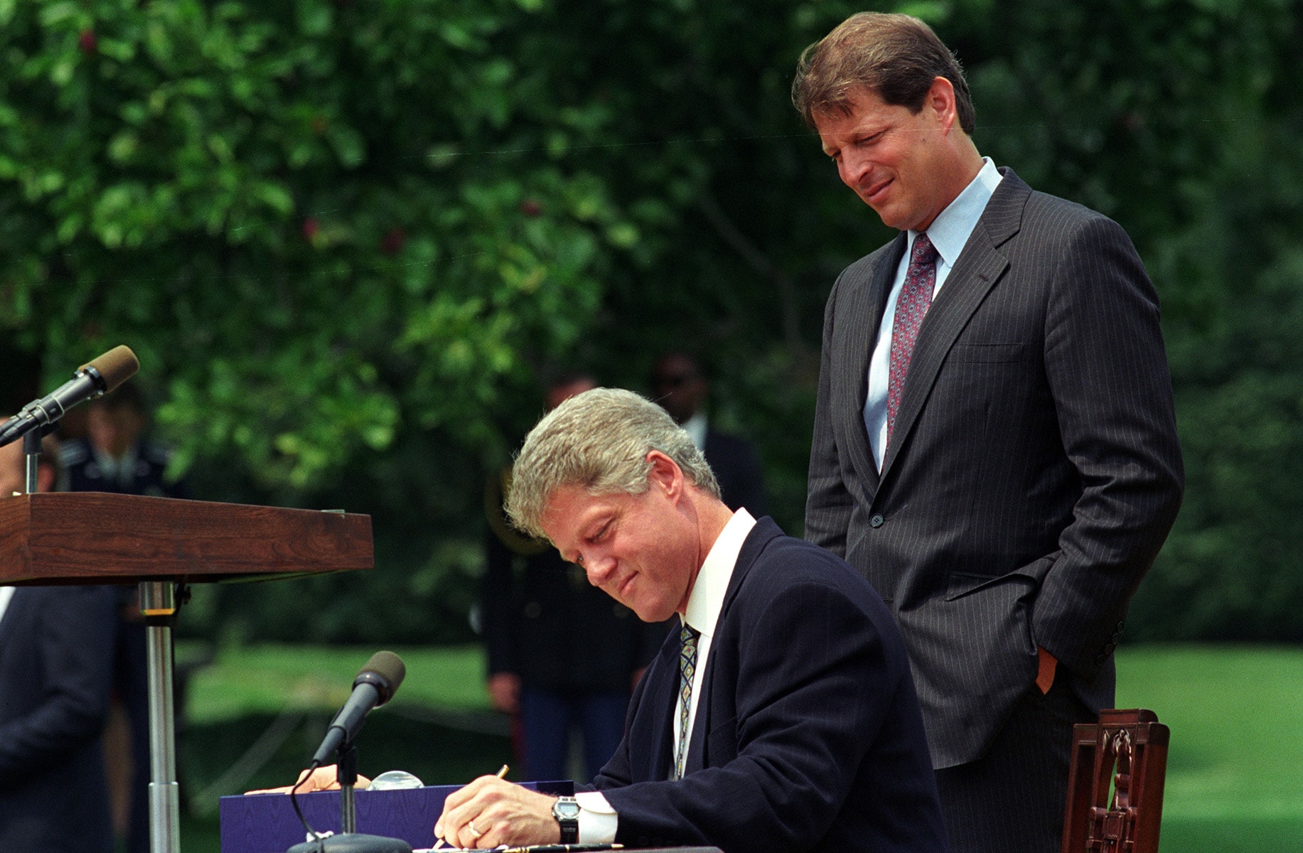 President Bill Clinton (seated) and Vice President Al Gore sign the CII Act in 1993.