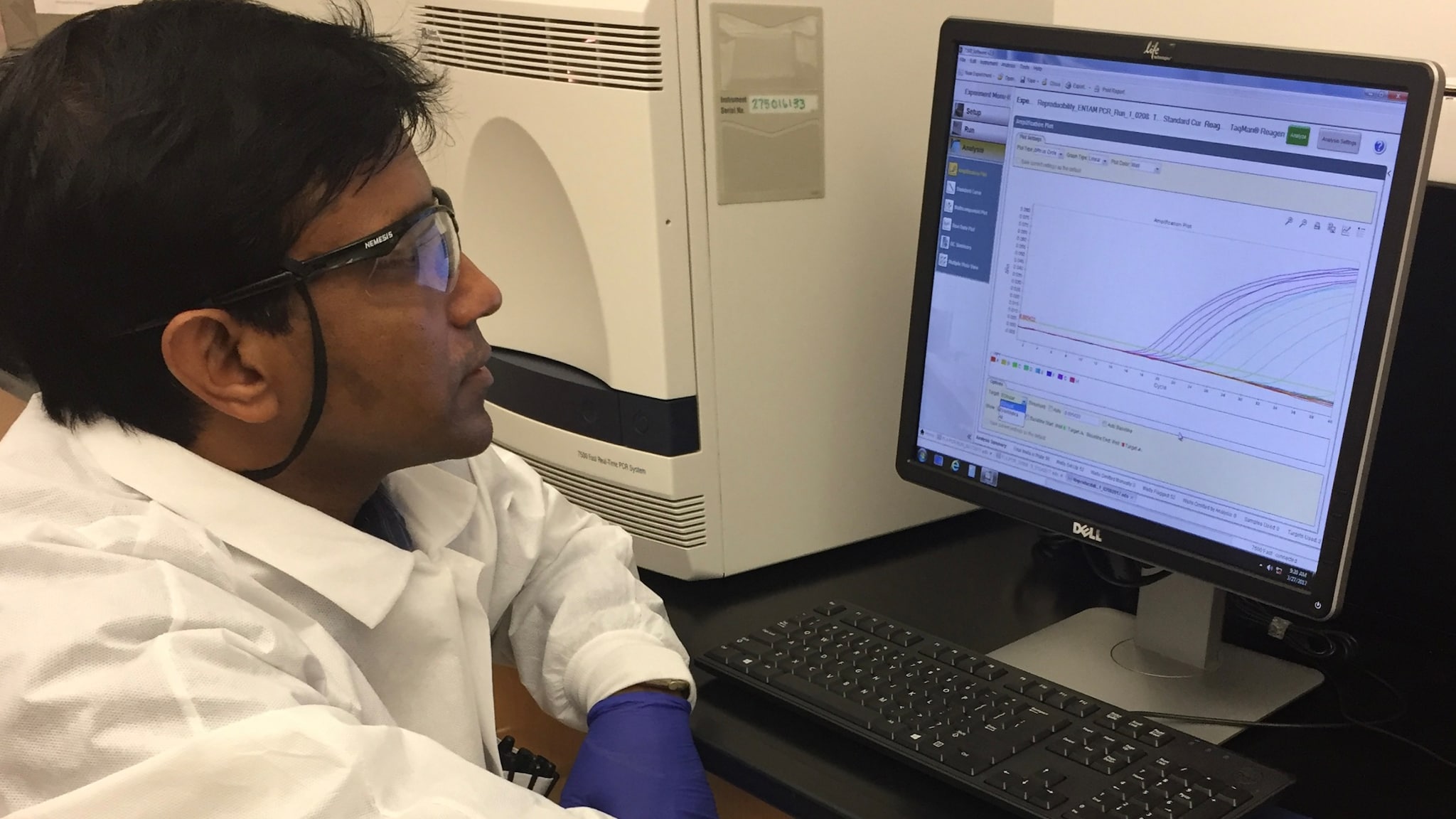 CDC scientist Shantanu Roy sits in front of computer and runs a test on a suspected case of Naegleria fowleri.
