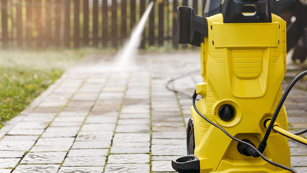 Pressure washer being used to clean outdoor patio