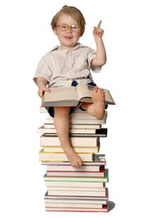 Boy sitting on stack of books