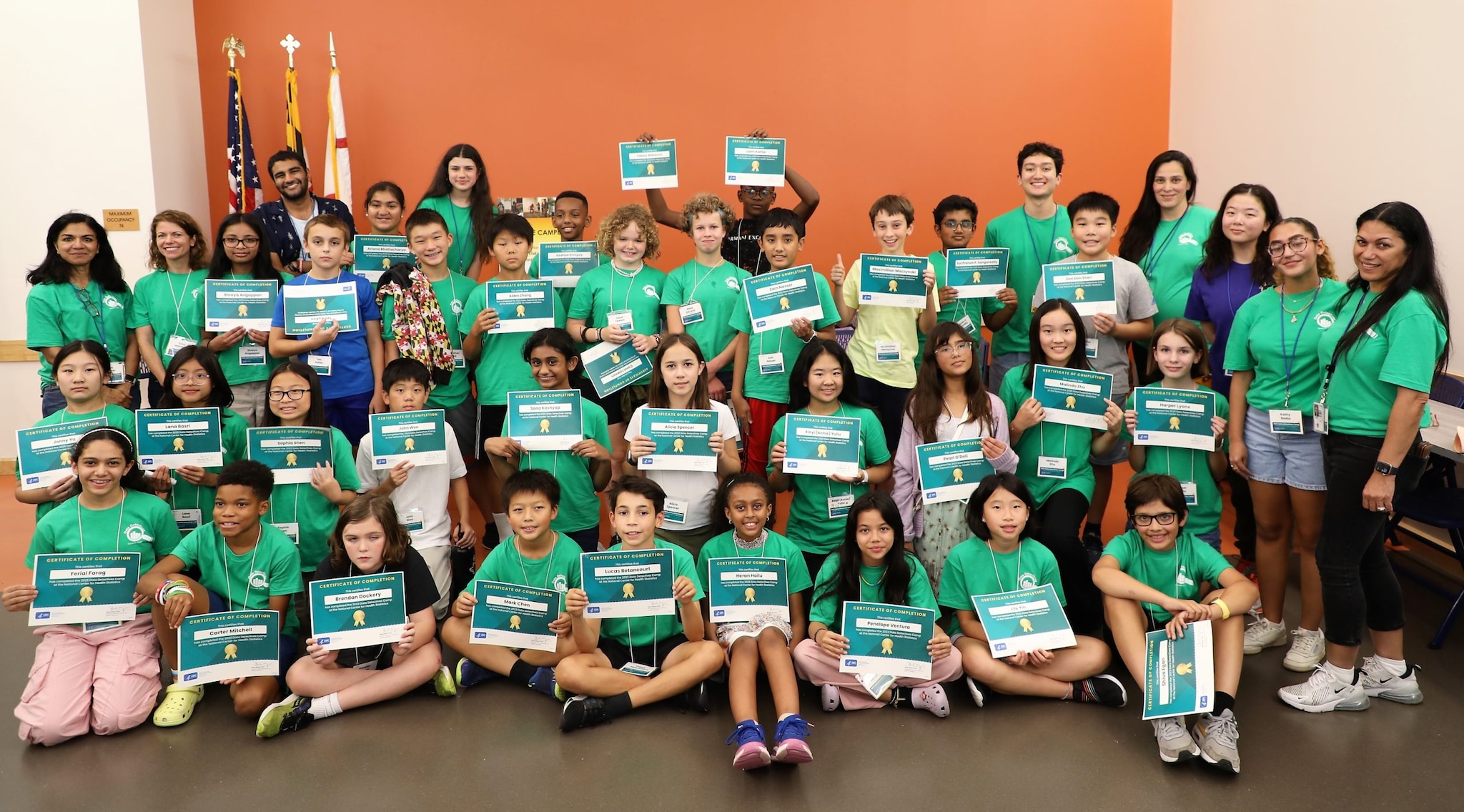 2023 camp group photo showing camp staff and more than 30 campers in green shirts holding certificates.