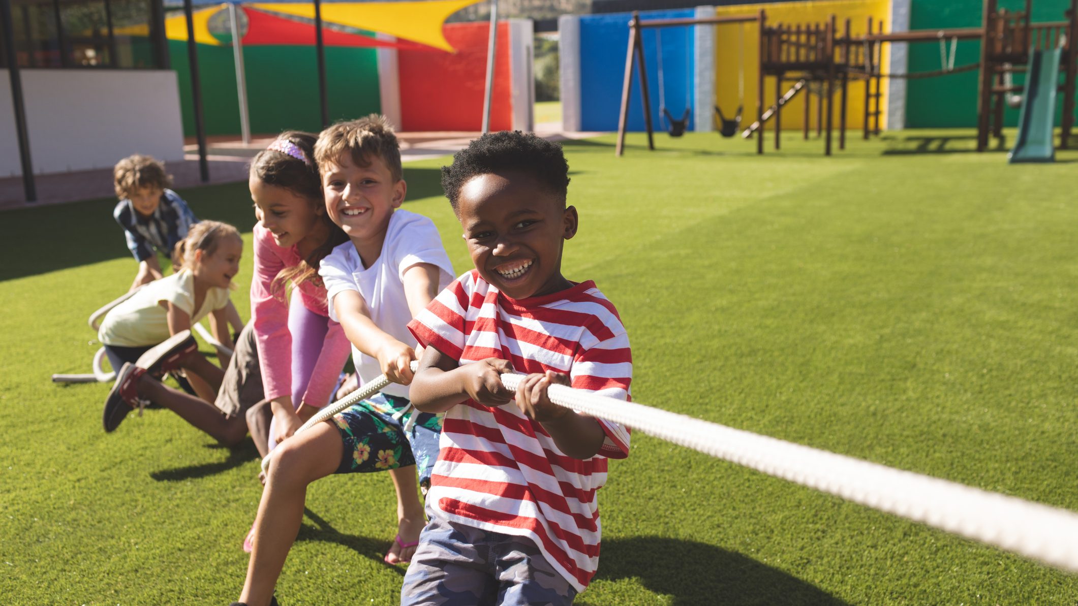 Group of school kids playing tug of war