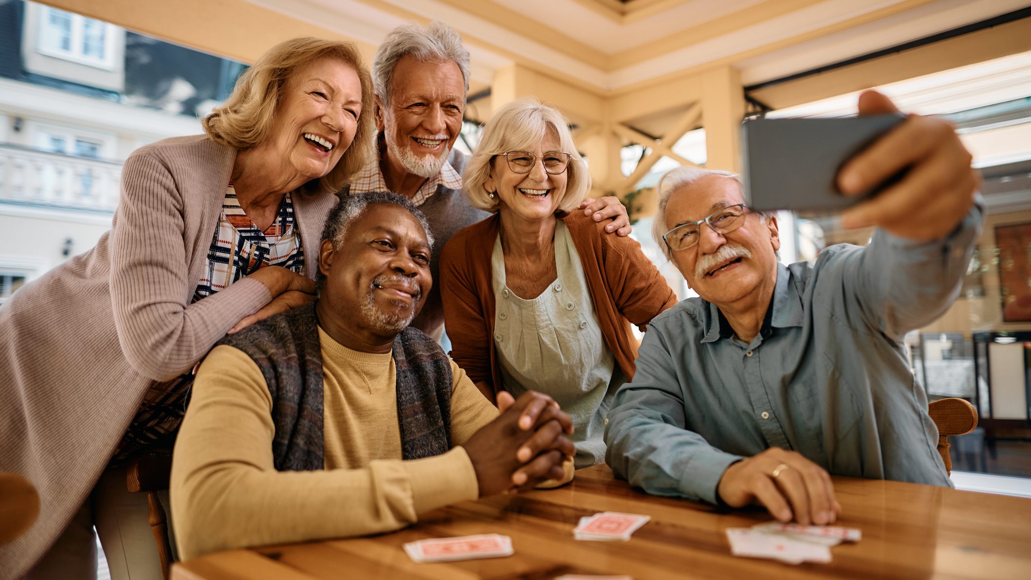 Cheerful senior having fun while taking selfie at retirement community.