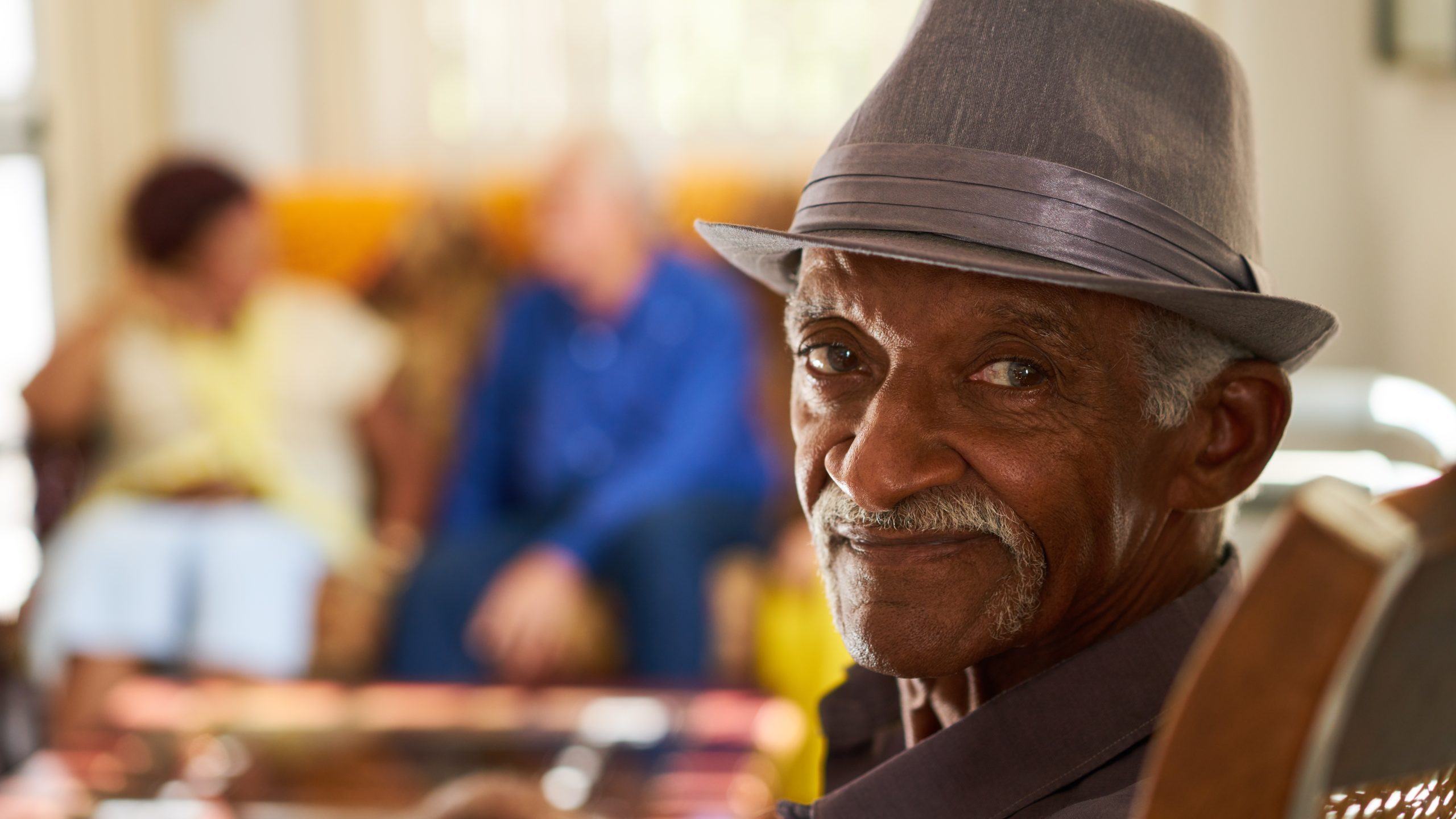 Senior Black Man With Hat Looking At Camera In Hospice