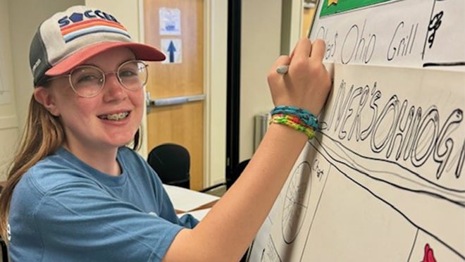 Girl writing on a board.