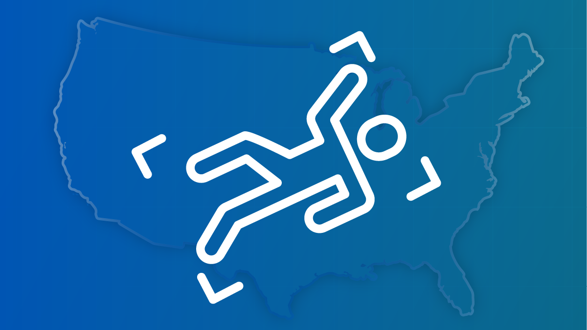 An outline of a person's outstretched body on the ground against a U.S. map.