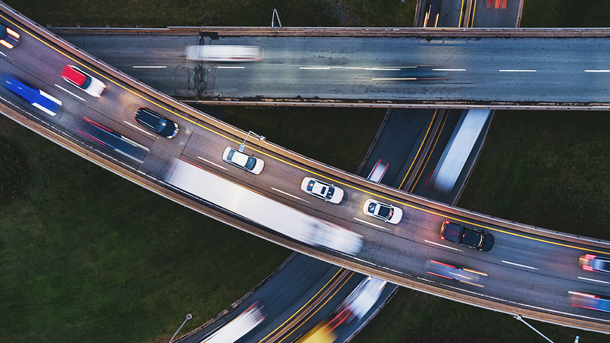Arial shot over cars whizzing by on multiple stretches of a major junction