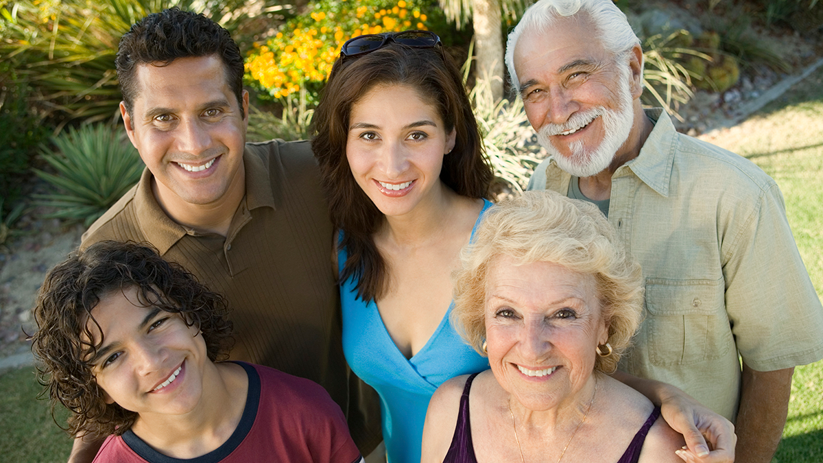 Family posed together outside includes older man and woman, younger man and woman, and male child