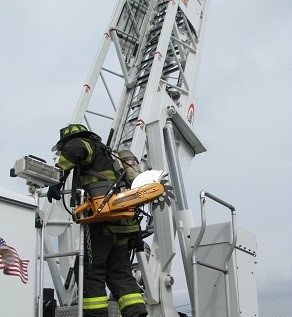 firefighter.jpg A fire chief demonstrates the challenges in accessing an aerial ladder and truck steps.