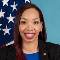 woman smiling with American flag in background