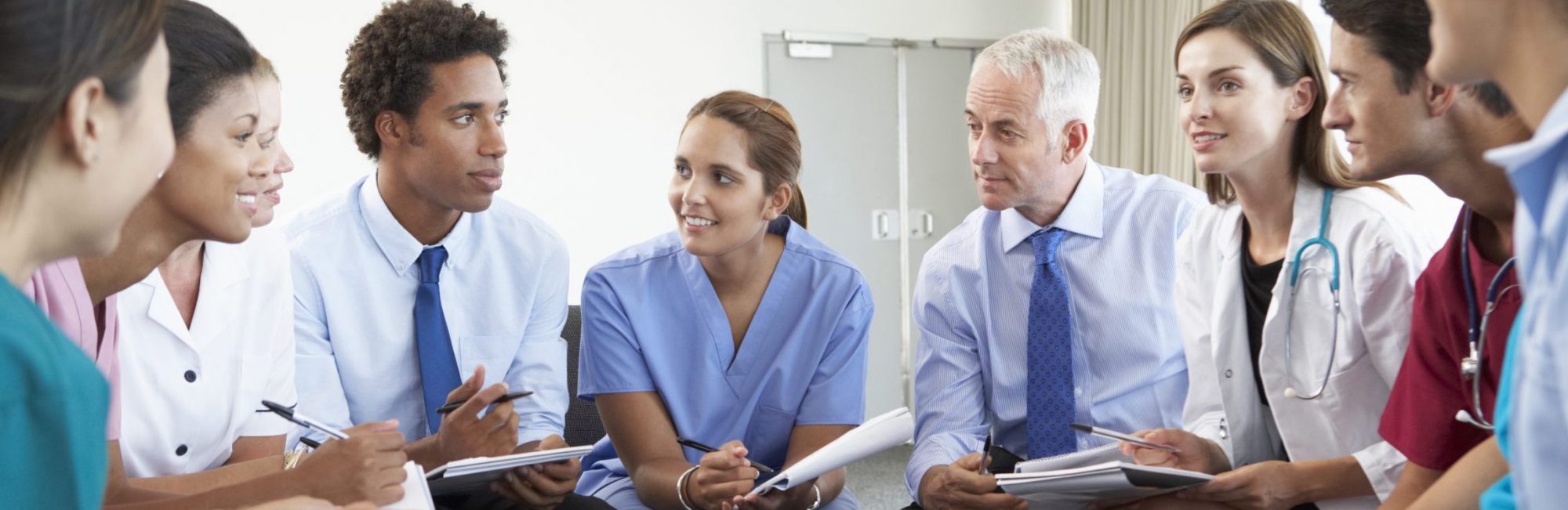 Medical Staff Seated In Circle At Case Meeting Medical Staff Seated In Circle At Case Meeting