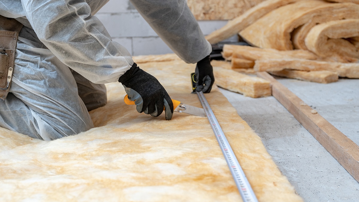 Professional workman installing thermal insulation rock wool