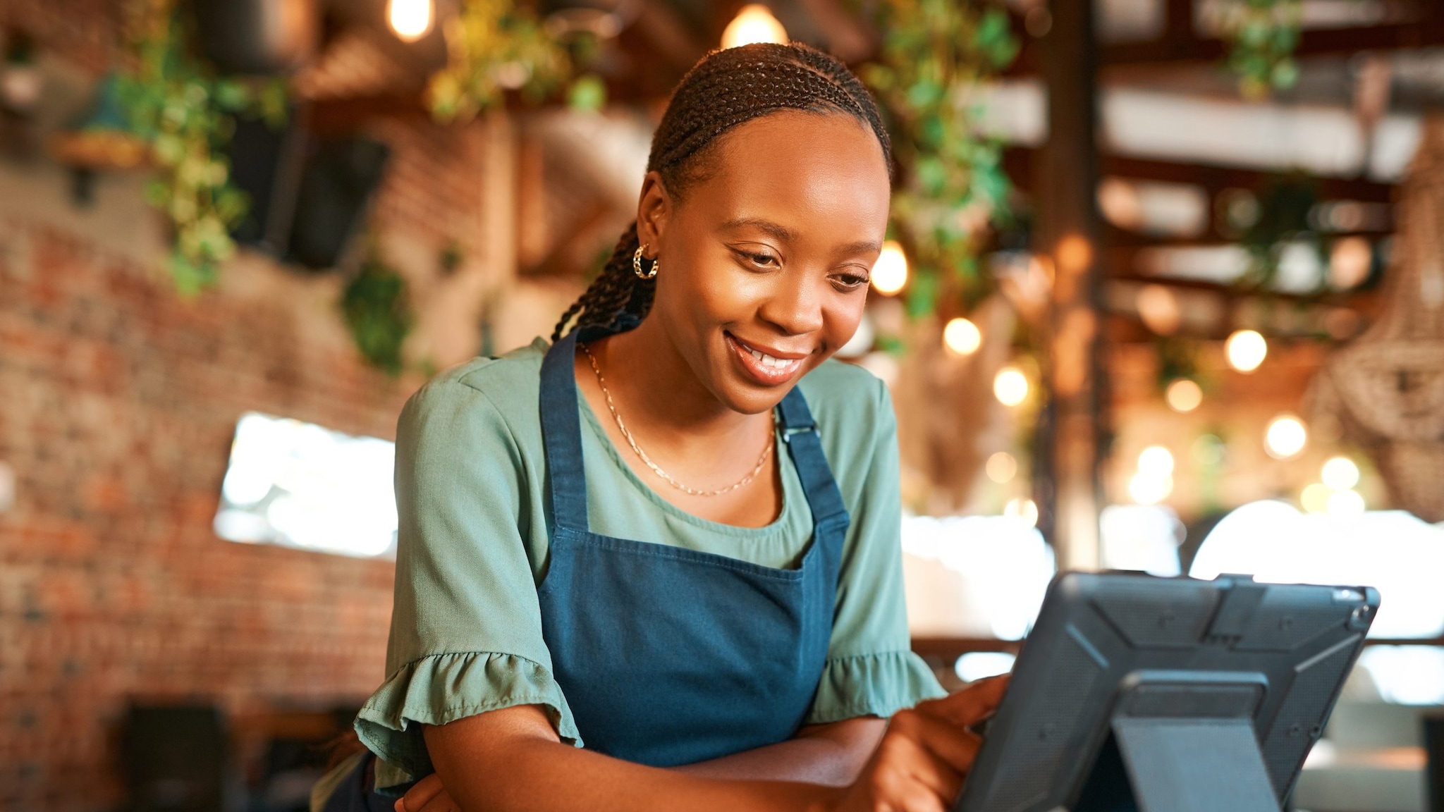 Black woman working the cash register at a restaurant.