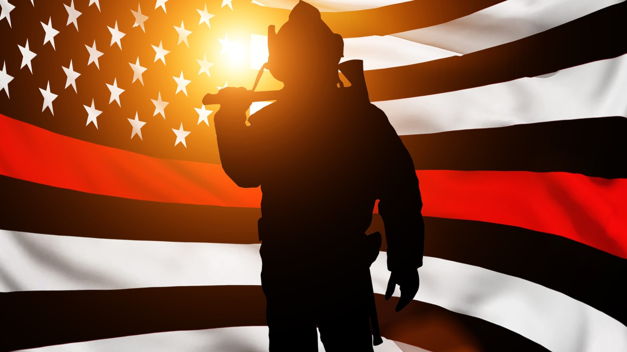 A silhouette of a firefighter holding an ax stands in front of a black and white American flag with one red stripe.