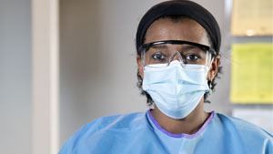 Image of a healthcare worker wearing eye protection and a surgical respirator.