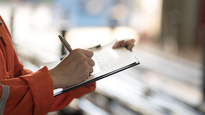 Individual writing on a clipboard
