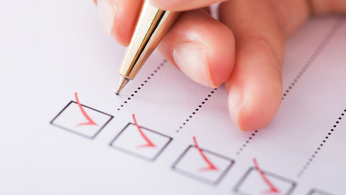 Person writing on a checklist.