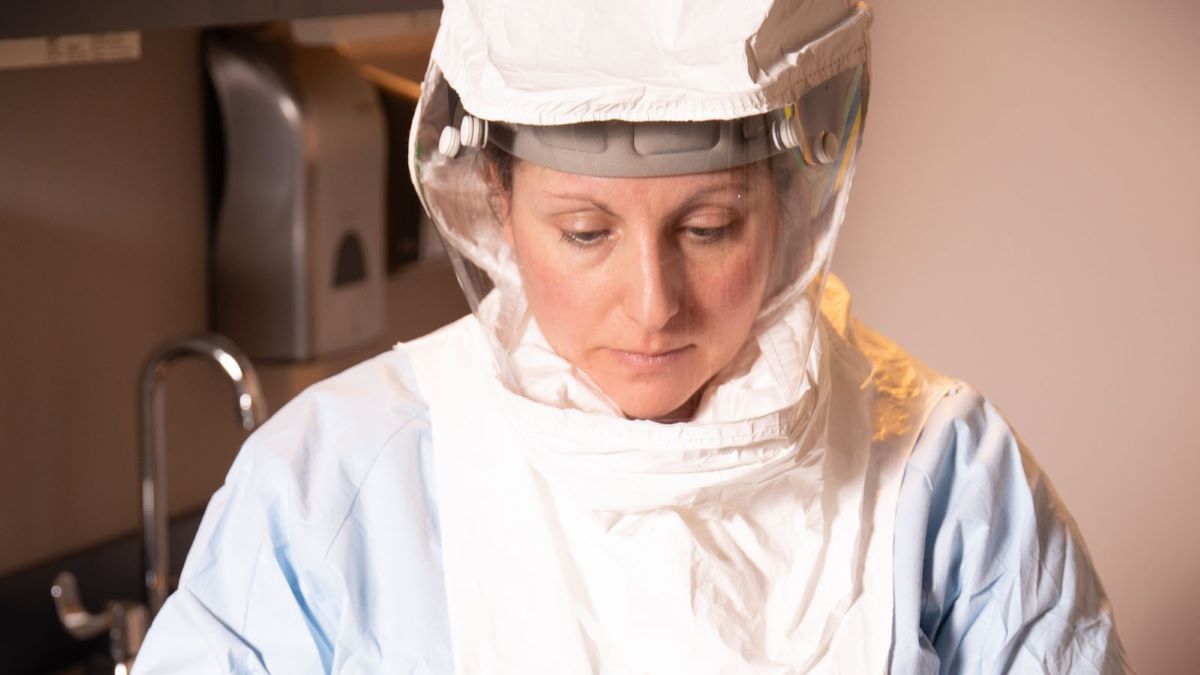 Healthcare worker looking down wearing a PAPR