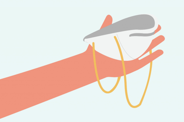 Hand holding N95 respirator with nose piece at the fingertips.