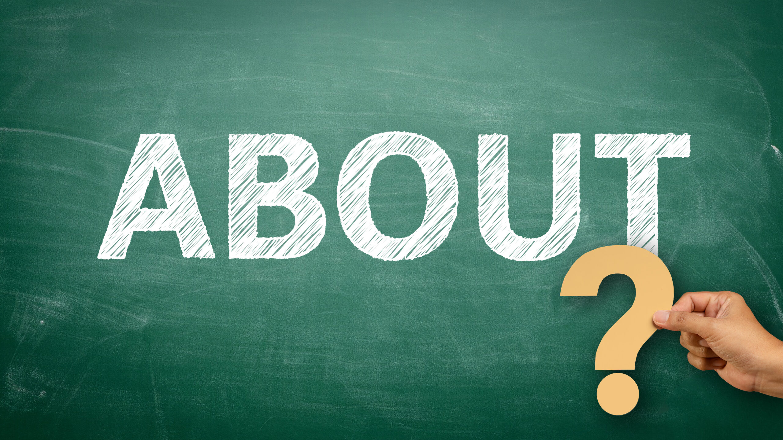 Hand writing "about" on chalkboard