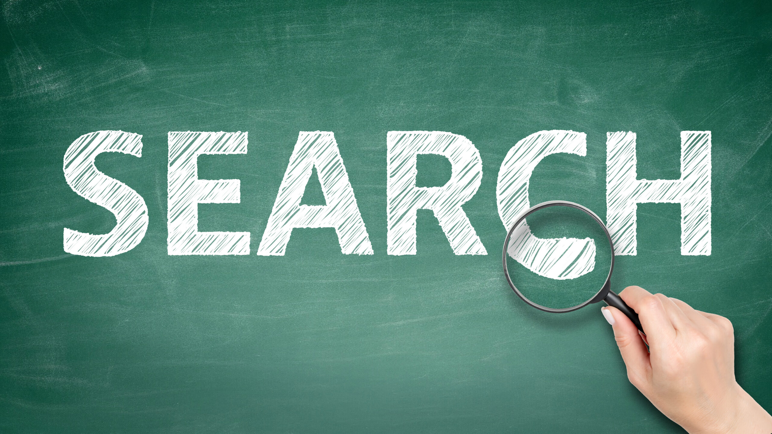 Chalkboard with hand writing "search" on it