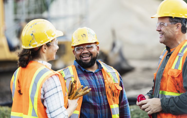 Trabajadores de construcción hablando y sonriendo