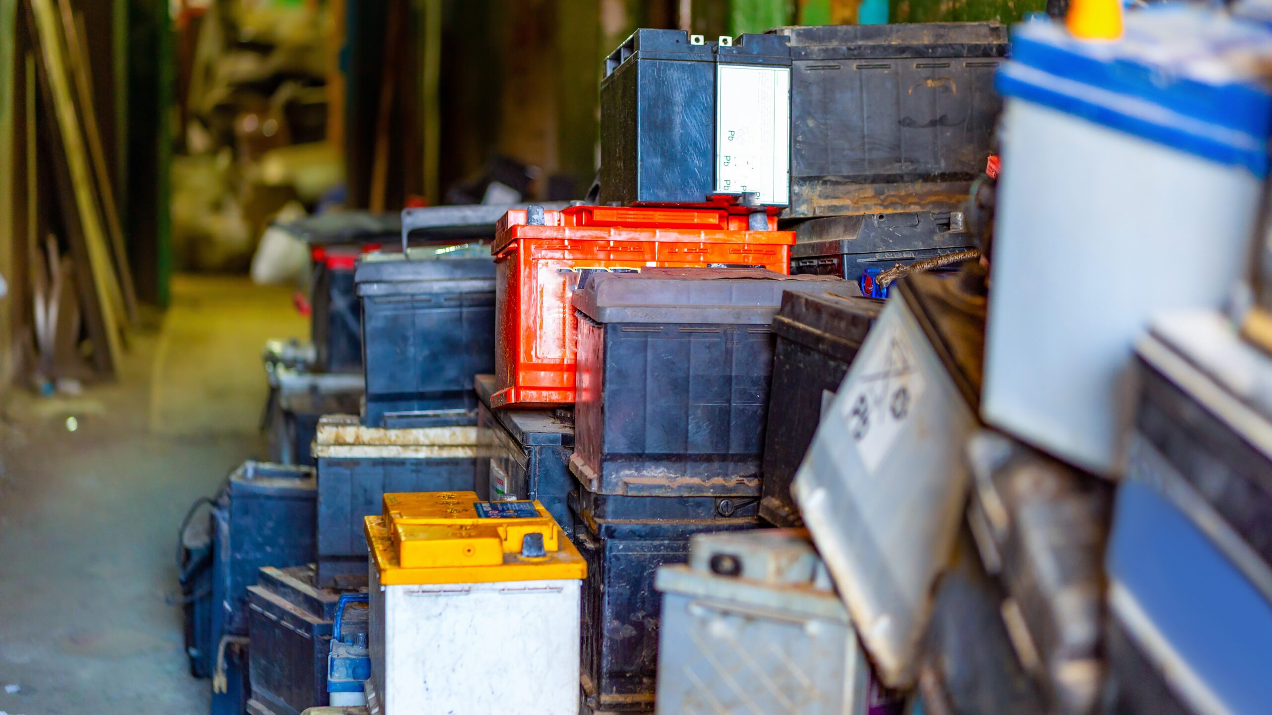 Discarded old car batteries in a garage for recycling in a lead scrap yard