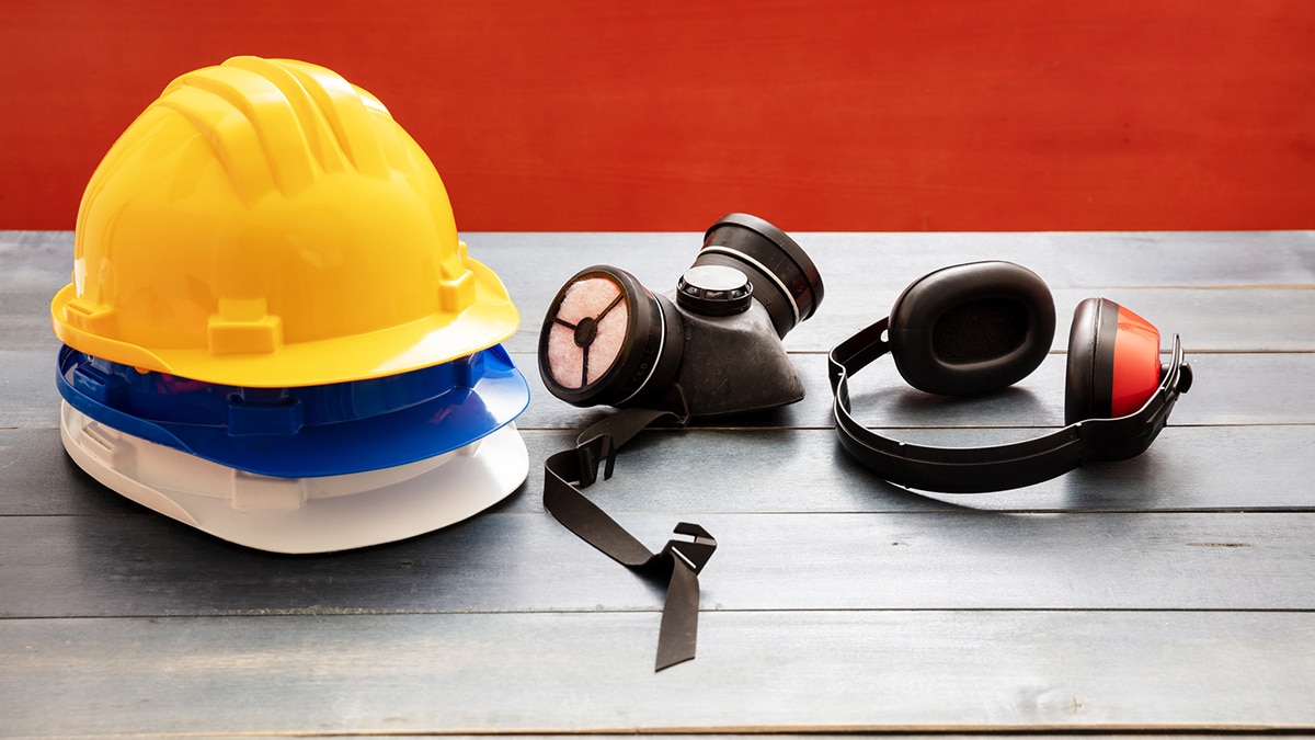 A collection of PPE including helmets, a respirator, and hearing protection.