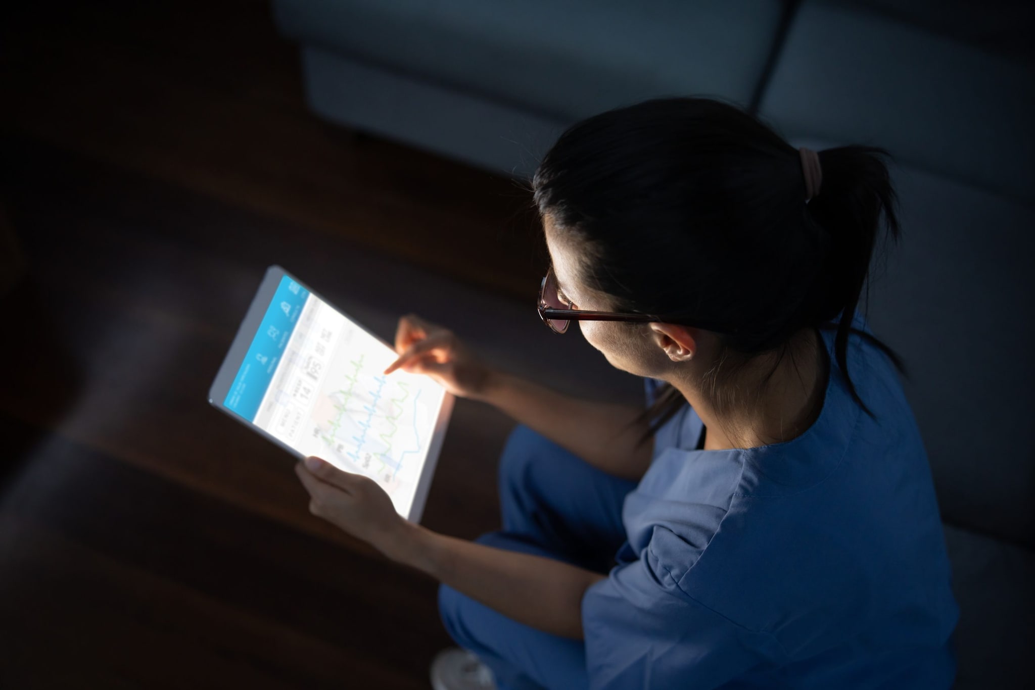 Una mujer trabajando en una tableta de noche