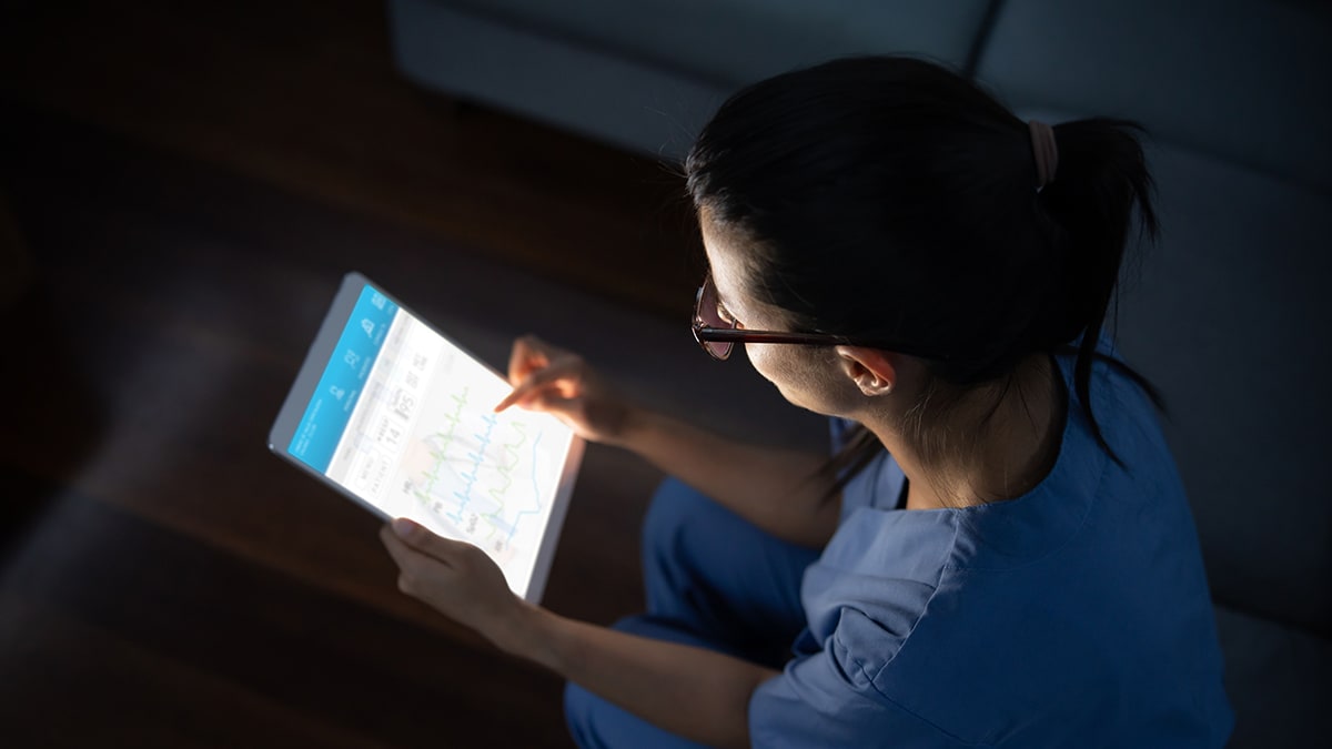 A woman working on a tablet at night