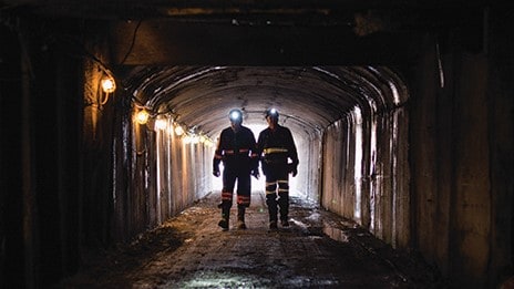 Two backlit miners in dark NIOSH Pittsburgh research mine entry 2018