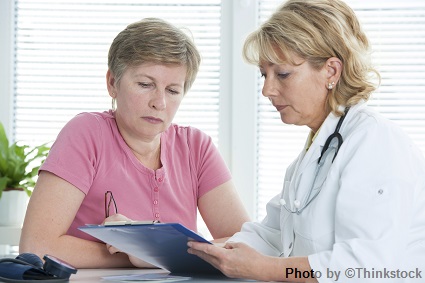 --no title-- A female doctor talks to her patient while holding a chart
