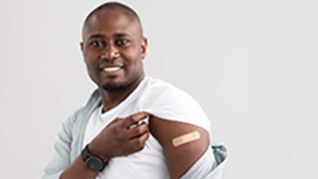 Man showing band-aid on arm following a vaccination