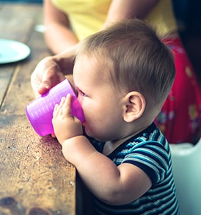 when should babies feed themselves with a spoon
