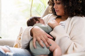 New mom watches as baby breastfeeds