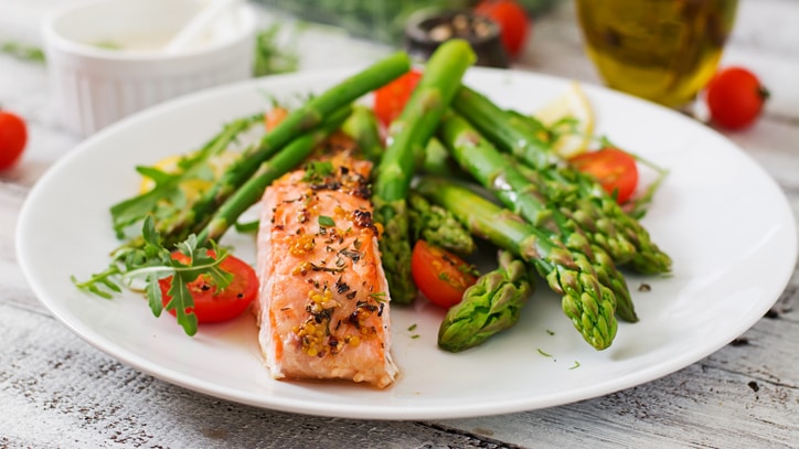 Healthy meal of salmon, asparagus, and cherry tomatoes.