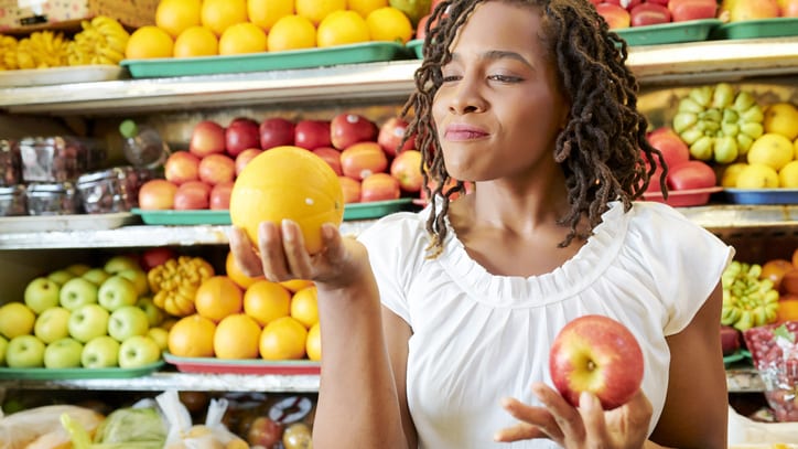 Woman admiring fruit in grocery store.