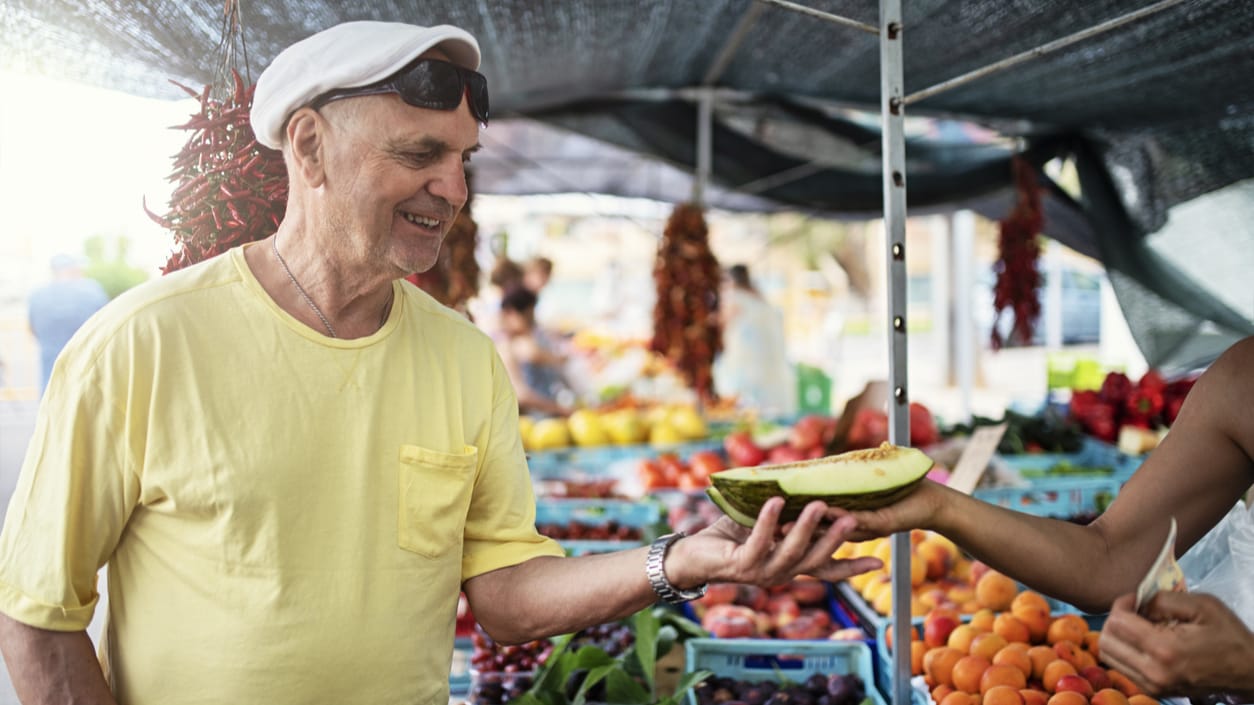 Man receiving fruit at farmers market